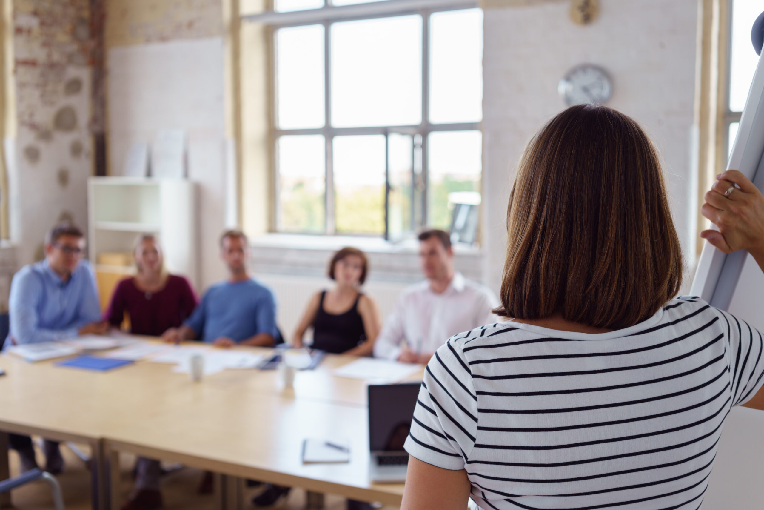 A lady speaking before a small group